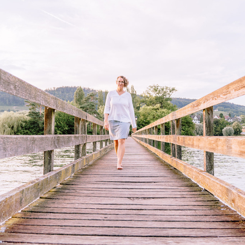 Corinna Fanni, Coach für Nervensystemregulation und emotionale Balance läuft beschwingt auf der Brücke der Insel Werd.