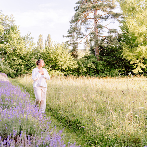 Corinna Fanni, Coach für Nervensystemregulation und emotionale Balance geniesst bewusst die Natur und die Sonne im Grünen.