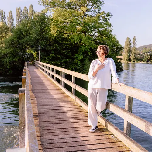 Corinna lehnt in Selbstverbundenheit am Brückengeländer der Insel Werd im Bodensee